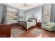 Serene bedroom featuring soft blue walls, hardwood floors, and a comfortable bed at 6494 W Matilda Ln, Glendale, AZ 85308