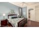 Cozy bedroom with blue walls, wood floors, ceiling fan, and ensuite bathroom at 6494 W Matilda Ln, Glendale, AZ 85308