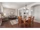 Open-concept living room with hardwood floors, dining table, and comfortable seating area at 6494 W Matilda Ln, Glendale, AZ 85308