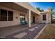 Covered patio with two chairs, neutral toned walls, and rock landscaping at 6494 W Matilda Ln, Glendale, AZ 85308