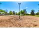 Sandy community volleyball court with netting and surrounding green space under a bright blue sky at 6494 W Matilda Ln, Glendale, AZ 85308