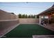 Spacious backyard features lush artificial turf, decorative stone, and ambient string lights overhead at 6926 W Spur Dr, Peoria, AZ 85383