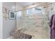 Bathroom showing glass enclosed shower with marble tile, and a built-in bench at 6926 W Spur Dr, Peoria, AZ 85383