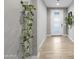 Bright entryway features wood-look tile floors, white trim, and a modern door with decorative hanging plants at 6926 W Spur Dr, Peoria, AZ 85383