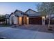 Attractive home with a brick driveway, two-car garage, and welcoming entrance with stone accents at 6926 W Spur Dr, Peoria, AZ 85383