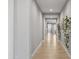 Hallway features wood-look tile floors, neutral walls, white trim, and decorative hanging plants at 6926 W Spur Dr, Peoria, AZ 85383