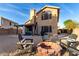 An outdoor seating area with a fire pit in a gravel backyard of a two-story home at 7371 W Louise Dr, Glendale, AZ 85310