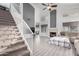 Open-concept living room and staircase featuring fireplace, light gray plank floors, and staircase at 7371 W Louise Dr, Glendale, AZ 85310