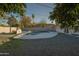 Backyard featuring mature trees, a refreshing swimming pool, and a concrete structure in the corner at 7819 N 17Th Ave, Phoenix, AZ 85021