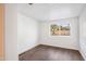 Bedroom featuring neutral paint, white trim, wood-look floors, and a bright window at 7819 N 17Th Ave, Phoenix, AZ 85021