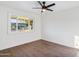 A bedroom with modern ceiling fan, wood-look floors, and a bright window at 7819 N 17Th Ave, Phoenix, AZ 85021