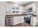 Modern kitchen features stainless steel appliances, white cabinets, granite counters and a bright window at 7819 N 17Th Ave, Phoenix, AZ 85021