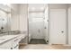 Bright bathroom featuring a walk-in shower with a frameless glass door and a white door at 7854 W Mockingbird Way, Florence, AZ 85132