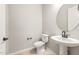Bathroom featuring a pedestal sink, round mirror and modern toilet at 7854 W Mockingbird Way, Florence, AZ 85132