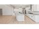 Bright, modern kitchen with white cabinets, stainless steel appliances, and a large island with granite countertops at 7854 W Mockingbird Way, Florence, AZ 85132
