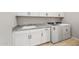 Laundry room with white cabinets, granite countertop, a stainless steel sink and new washer and dryer at 7854 W Mockingbird Way, Florence, AZ 85132