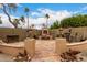 Relaxing backyard with outdoor kitchen area, fireplace and desert landscaping at 7866 W Taro Ln, Glendale, AZ 85308