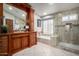 Bathroom featuring tile, bathtub, step-in shower with glass doors, and a wood vanity at 7866 W Taro Ln, Glendale, AZ 85308