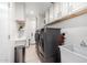 Laundry room with stainless steel washer and dryer and plenty of storage cabinets at 7866 W Taro Ln, Glendale, AZ 85308