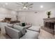 Inviting living room area featuring a brick fireplace, light tile flooring, and a comfortable sectional couch at 7866 W Taro Ln, Glendale, AZ 85308