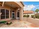 Covered patio with stone flooring, a view of the backyard, stucco walls, and outdoor access, perfect for outdoor relaxation at 7866 W Taro Ln, Glendale, AZ 85308