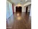 Inviting living room with a brick archway feature, complemented by sheer curtains and wood flooring at 7921 W Pinchot Ave, Phoenix, AZ 85033