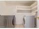 Laundry room with modern washer and dryer units and ample storage shelving at 800 W 12Th St, Tempe, AZ 85281