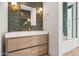 Stylish bathroom featuring a modern vanity with wood cabinets, sleek white countertop, and gold fixtures at 8206 E Del Camino Dr, Scottsdale, AZ 85258