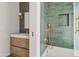 Bathroom showcasing modern vanity, green tile, gold fixtures, and a glass-enclosed tub and shower at 8206 E Del Camino Dr, Scottsdale, AZ 85258