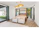 Bedroom with four-poster bed, slider to backyard, modern lighting, and herringbone-patterned floors at 8206 E Del Camino Dr, Scottsdale, AZ 85258