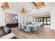 Open dining area with view of kitchen, stylish seating, modern pendant lights and herringbone floors at 8206 E Del Camino Dr, Scottsdale, AZ 85258