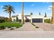 Beautiful home featuring a manicured lawn, palm trees, and a brick pathway leading to the entrance at 8206 E Del Camino Dr, Scottsdale, AZ 85258