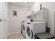 This laundry room features tile floors, a shelf, a washing machine, and a dryer at 8740 W San Miguel Ave, Glendale, AZ 85305