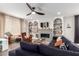 Bright living room featuring a modern ceiling fan, tiled fireplace, built-in shelves, and comfortable sectional sofa at 8740 W San Miguel Ave, Glendale, AZ 85305