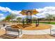 Community playground with a shade cover, climbing structure, swings and bench seating for parents at 8740 W San Miguel Ave, Glendale, AZ 85305