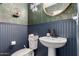 Stylish powder room featuring elegant floral wallpaper, beadboard, and modern fixtures at 8740 W San Miguel Ave, Glendale, AZ 85305