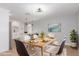 Bright dining room boasts an open floor plan, stylish light fixture, and seats six at the wooden table at 9127 E Broadway Rd, Mesa, AZ 85208