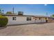 Cozy single-story home featuring desert landscaping, covered entryway, and clean, white exterior at 9127 E Broadway Rd, Mesa, AZ 85208