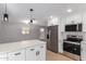 Modern kitchen features white cabinets, stainless steel appliances, and an island with a white countertop at 9127 E Broadway Rd, Mesa, AZ 85208