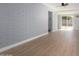 Living room with light blue brick walls, wood floor and glass sliding door at 9127 E Broadway Rd, Mesa, AZ 85208