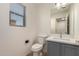 Bathroom featuring a window, toilet, and sink at 9643 N 81St Dr, Peoria, AZ 85345