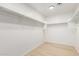 Walk-in closet with hanging racks and hardwood floors at 9643 N 81St Dr, Peoria, AZ 85345