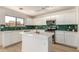 Open plan kitchen with white cabinetry, stainless steel appliances, and green backsplash tiles at 9643 N 81St Dr, Peoria, AZ 85345