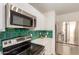 Close up of the modern kitchen and appliances with green tile backsplash at 9643 N 81St Dr, Peoria, AZ 85345