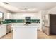 Modern kitchen with stainless steel appliances, stylish green backsplash, and a center island at 9643 N 81St Dr, Peoria, AZ 85345