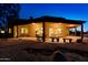 Relaxing backyard patio area at night with ample seating and desert landscape at 10303 E Hummingbird Ln, Gold Canyon, AZ 85118