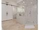 Bright bathroom with a frameless glass shower, white tile, and a barn door entry at 10534 N 133Rd St, Scottsdale, AZ 85259