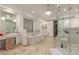 Luxurious bathroom with a soaking tub, dual vanities, elegant lighting, and glass shower at 10534 N 133Rd St, Scottsdale, AZ 85259