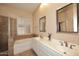 Well-lit bathroom featuring double sinks, plantation shutters, a soaking tub and tile surround shower at 10572 E Tierra Buena Ln, Scottsdale, AZ 85255