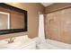 Cozy bathroom with tile surround tub/shower, framed mirror, and single sink vanity at 10572 E Tierra Buena Ln, Scottsdale, AZ 85255